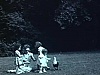 Une femme et trois enfants sur le gazon 