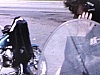 À la station-service, un homme répare la moto avec sa blonde, très typée Rock'n'roll.