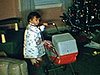 Cadeaux de Noël et fillette: la petite joue avec ses jouets (en jupette de Noël)