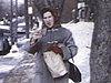 Jeune femme qui mange un croissant sur la rue, à Montréal, en rentrant à la maison