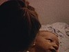 Bébé dans les bras d'une petite fille, puis dans les bras de sa jolie maman