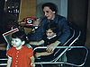 Mère et enfant devant belle poupée et petite fille à robe rouge qui embrasse la poupée 