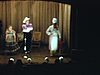 Beaux plans mais flous; Willie Lamothe en costume de cow-boy accompagné d'une femme et d'un accordéoniste sur scène, en spectacle; petits sketchs rigolos (vedette)