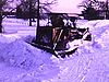 Tracteur en action dans la neige (bulldozer qui déneige le chemin et l'entrée)