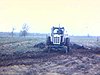 Tracteur Oliver qui labourre un champ; le tracteur en action, puis un homme en sort en veston/cravate (agriculture)
