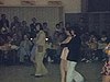 Salle de danse; couples dansent le triple swing devant public