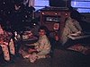 Noël; enfants qui déballent leurs cadeaux (piano miniature, toupie, jeux d'animaux; une fillette lance les pantoufles (mocassins) qu'elle a reçues