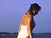 Jeune fille pin-up en maillot à jupette plonge à la mer à partir du yacht. Elle salue la caméra, grand sourire. Baignade de jeunes couples, jeune fille fait la planche