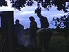 Jeunes couples préparent un feu de camp près du chalet. ils roulent du papier journal