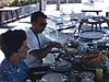 Repas sur la terrasse à Acapulco. la femme porte un chapeau de plage spectaculaire et laid