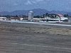 Plan filmé du hublot de l'avion qui décolle (départ), puis des plans en vol