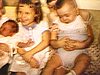 Enfants avec bébé dans leurs bras, frères et soeurs assis à la cuisine avec bébé (beau plan)