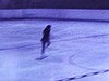 Patinage artistique féminin solo, puis de groupe; spectacle avec éclairage; beau plan de près d'une patineuse vedette