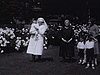 Famille avec la nounou infirmière (grand-mère et petit fils); bye-bye à la caméra