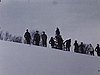 Suite du ski sur le domaine familial: ils remontent la pente en skis; tous en haut de la côte: départ de tous ensemble (beau plan)