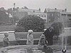 Années 20; enfants et mémé dans un parc au bassin d'eau; ils jouent avec des chaloupes miniatures