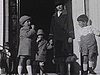 Années 20; La famille devant l'entrée de la maison; on sautille; un couple descend; la gouvernante et les deux enfants posent devant la voiture