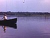 Beaux plans d'un jeune homme en chaloupe sur un lac avec fillette et jeune femme; une autre chaloupe avec toute la fmille dedans