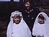 Communiantes à l'extérieur puis différents membres de la famille sur le gazon, devant le fleuve