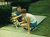 Enfants autour du chien beagle, devant la maison, près de la rue