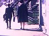 Madame et jeune garçon qui déambulent sur une rue de Montréal avec escaliers extérieurs (bon plan) Ils entrent dans une maison