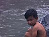 Vue de petits enfants mexicains sur le bord de la rivière (Beaux plans) Deux dames touristes les rejoignent pour la baignade.