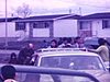 Départ d'une automobile filmé de la vitre arrière. route de bungalows de banlieue qui défilent.