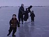 Famille patine sur la rivière, les enfants tombent, toute la famille s'amuse