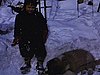 Années 50: hiver, garçon emmitouflé en patin, avec un chien st-bernard couché dans la neige apprend à patiner et joue au hockey