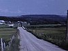 Route l'été, pont couvert, vue du village filmée de l'auto qui roule