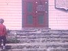 Madame entre dans une petite église, «Vieille chapelle de Tadoussac, construite en 1747» (pancarte)
