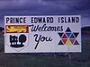 Pancarte «Prince Edward Island», madame montre du doigt le panneau routier «Montague/Charlottetown»