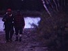 Chasse à l'orignal - deux chasseurs dans le bois au bord de l'eau 