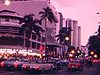 Hawaï - le soir - la ville, les hôtels et les automobiles (night life) pousse-pousse bicyclette (conductrice porte une tuque de Noël)