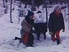 Un couple pose devant un bonhomme de neige qui porte des culottes