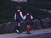 Très beau plan du départ de la maison de deux petites fille pour leur première journée d'école. Elles quittent en se tenant la main, sautillant sur le trottoir, de dos