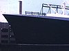 Vue générale du gros paquebot Le France au port de New York; du quai, puis sur le pont - chaises transat, canots de sauvetage et différents étages extérieurs