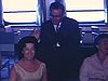Groupe de touristes chics pose et se repose dans un salon du paquebot «Le France» vue générale du salon, piano à queuet et décorations; d'autres arrivent
