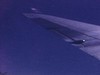 Aile d'avion dans le ciel filmé du hublot. Puis plans des nuages