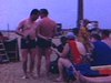 Plage d'Espagne: un homme avec sa caméra 8mm filme et l'on voit des touristes étendus sur leurs chaises longues