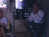 Homme devant bar portatif contenant 2 bouteilles de Bols Gin (alcool) Motel, gros plan sur les bouteilles