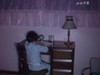 Fillette fait ses devoirs sur son bureau et maman l'aide, puis fillette au salon avec papa qui la berce, et grand-papa