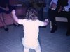 Réunion de famille (Noël ou jour de l'An), bébé fille danse au milieu de sa famille (beau plan)