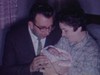 Papa et maman tiennent bébé dans leurs bras, lui donne des baiser (beau plan)