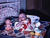 Bébé dans chaise haute, dans la cuisine, entouré de jouets