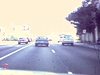 D'une auto qui roule, vue d'un hôtel, de la ville, du bord de l'eau (Floride?)