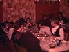 Noël ou jour de l'An au sous-sol, parenté arrive; danse dans le salon, famille nombreuse, ronde. Grands-parents dansent, pose pour la photo de famille