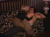 Couple sur le divan du salon, femme assise sur l'homme qui est couché, ils s'embrassent (amour)