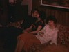 Noël, famille élargie (le soir) au salon, toute la parenté, couple s'embrasse sur le sofa des années 70