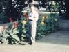 Monsieur pose devant des fleurs et des plantes exotiques aux Caraïbes ou Afrique(?)